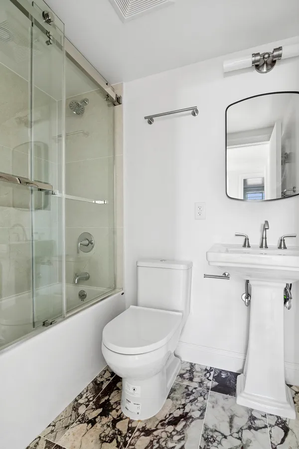 a bathroom with a toilet sink and shower