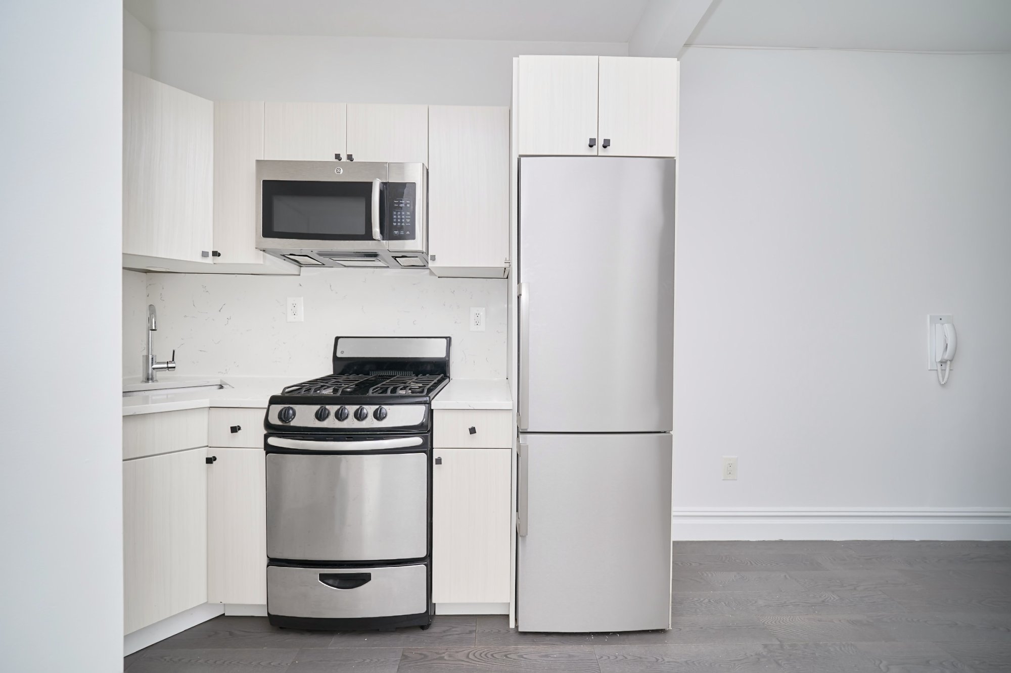 20 Avenue A, Unit 5E Manhattan, NY 10009 - Photo 3 of 8 a kitchen with white cabinets and stainless steel appliances
