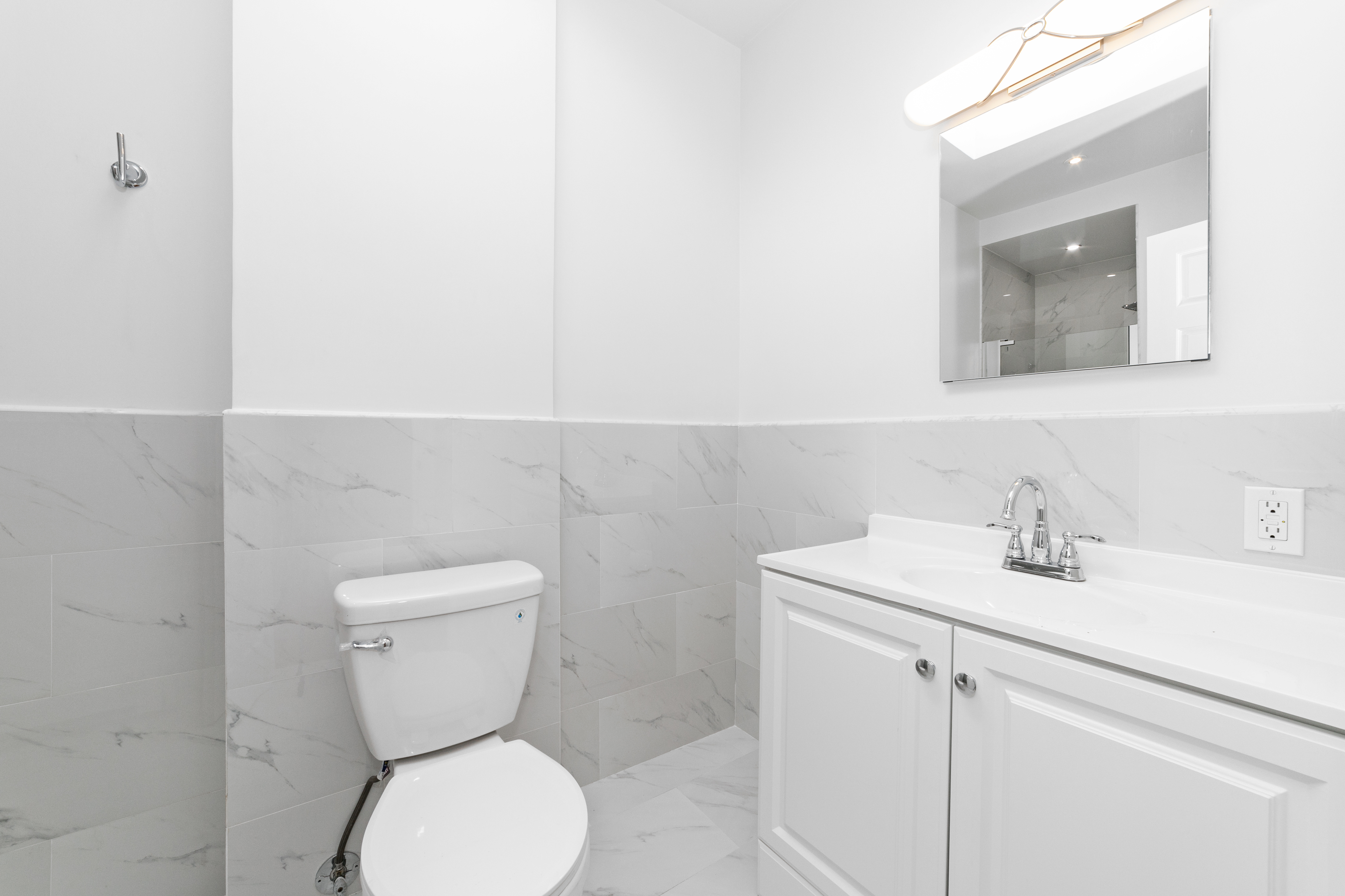 24-41 82nd Street Queens, NY 11370 - Photo 12 of 15 a bathroom with a toilet sink and mirror
