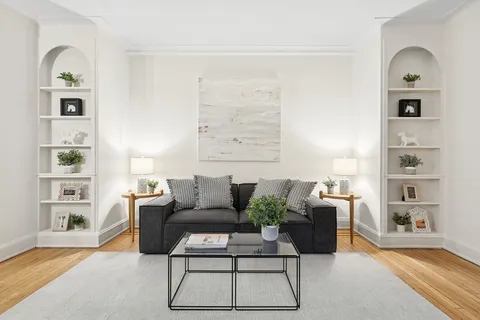 a living room with furniture a rug and white walls