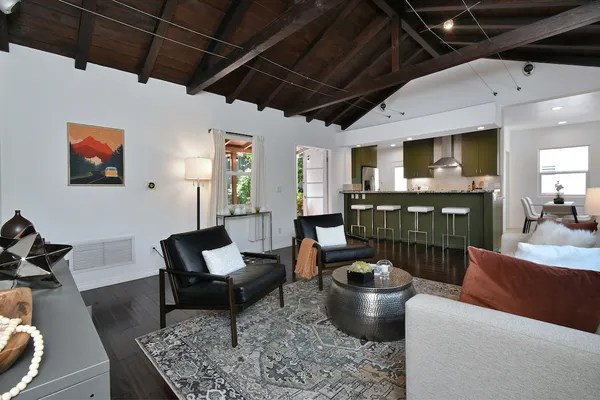 a kitchen with stainless steel appliances granite countertop a table chairs sink and cabinets