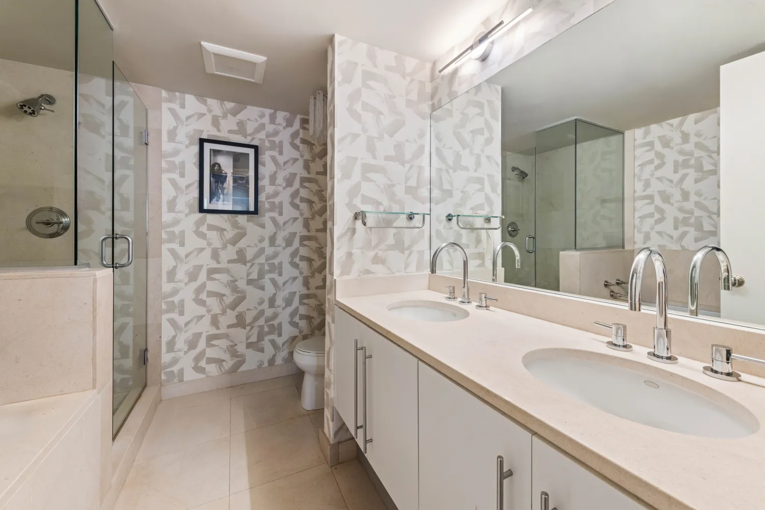 a bathroom with a double vanity sink mirror and shower