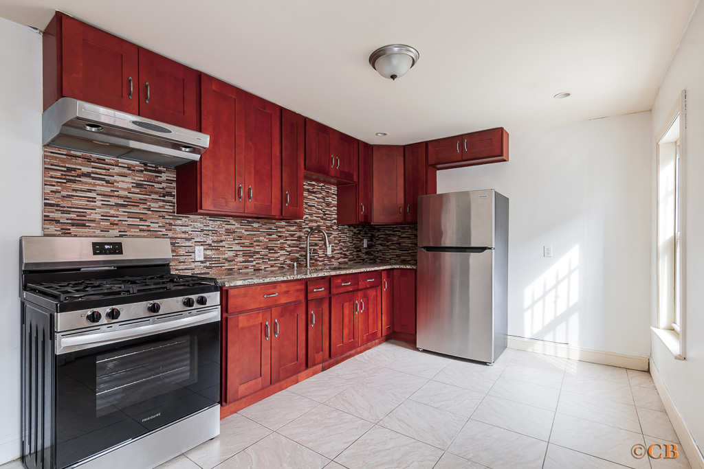 149 Van Buren Street, Unit GARDEN Brooklyn, NY 11221 - Photo 2 of 6 a kitchen with stainless steel appliances granite countertop a stove top oven a refrigerator and a sink with granite countertops