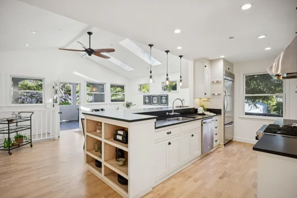 a kitchen with stainless steel appliances granite countertop a sink stove and wooden floor