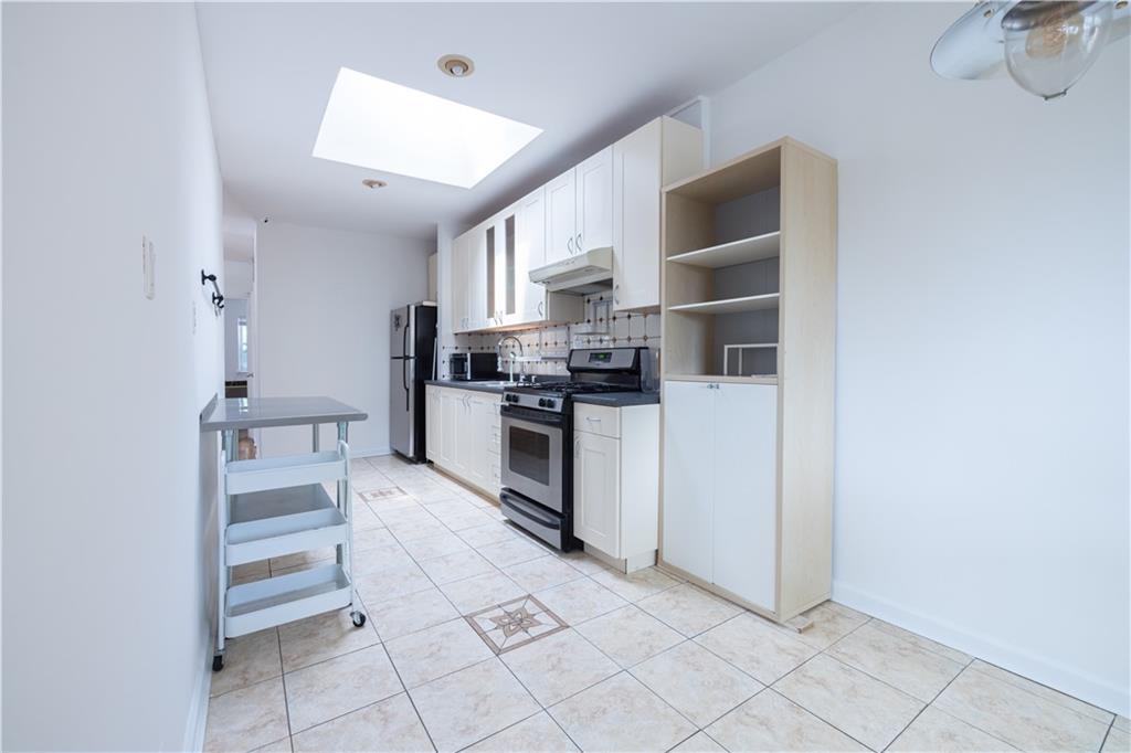 1506 Dahill Road Brooklyn, NY 11204 - Photo 10 of 13 a kitchen with white cabinets and appliances