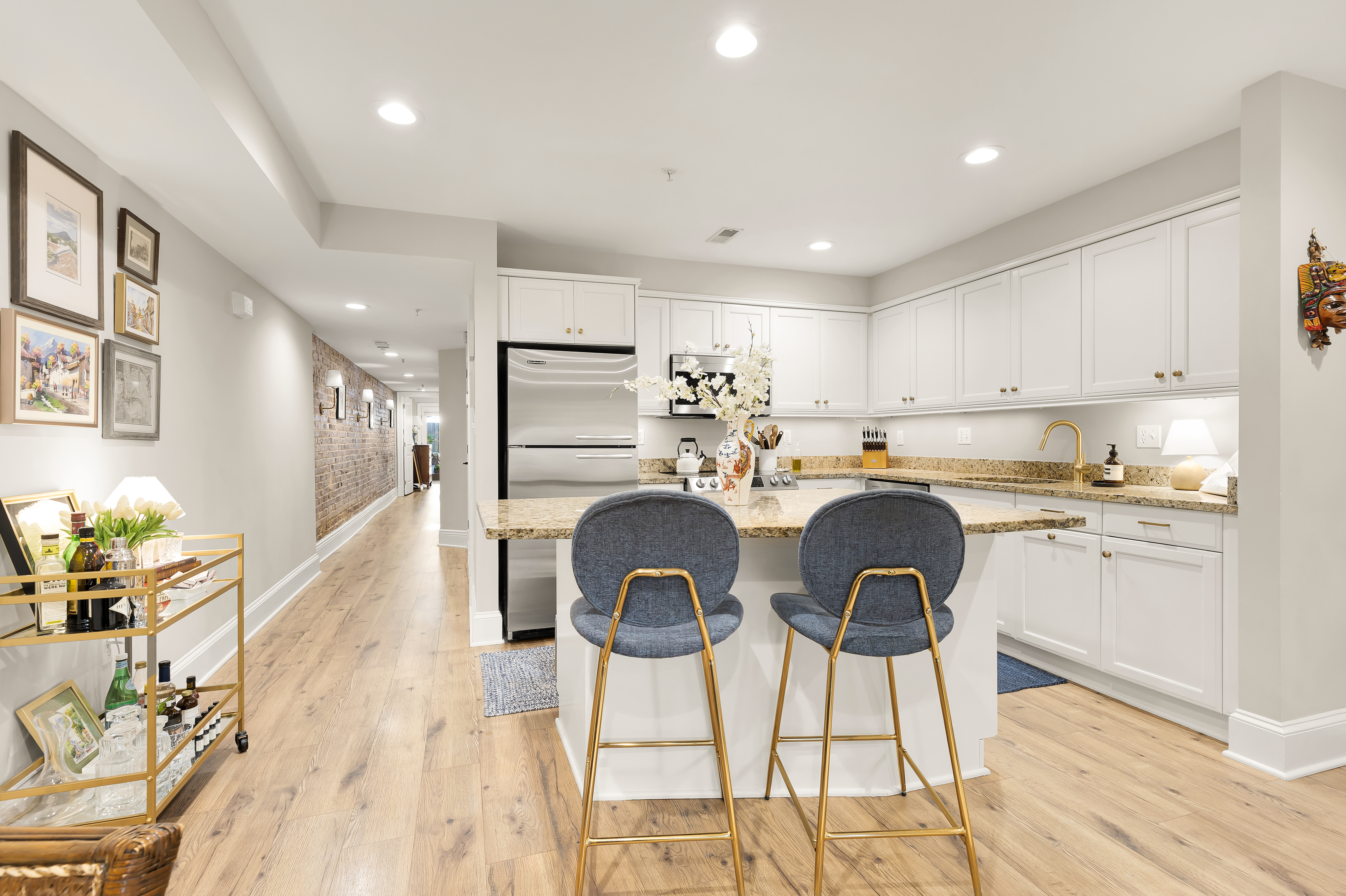 1354 Kenyon Street Northwest, Unit G Washington, DC 20010 - Photo 10 of 35 a kitchen with kitchen island granite countertop a dining table chairs cabinets a sink and a counter top space