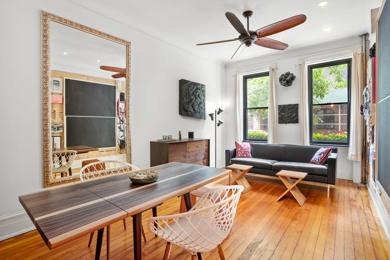 a living room with furniture a flat screen tv and a floor to ceiling window