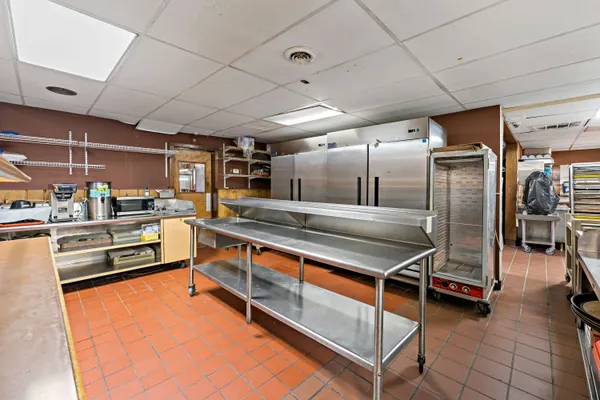 a open kitchen with stainless steel appliances kitchen island granite countertop a sink a counter space and cabinets