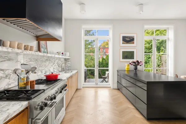 a kitchen filled with stainless steel appliances a stove and a window