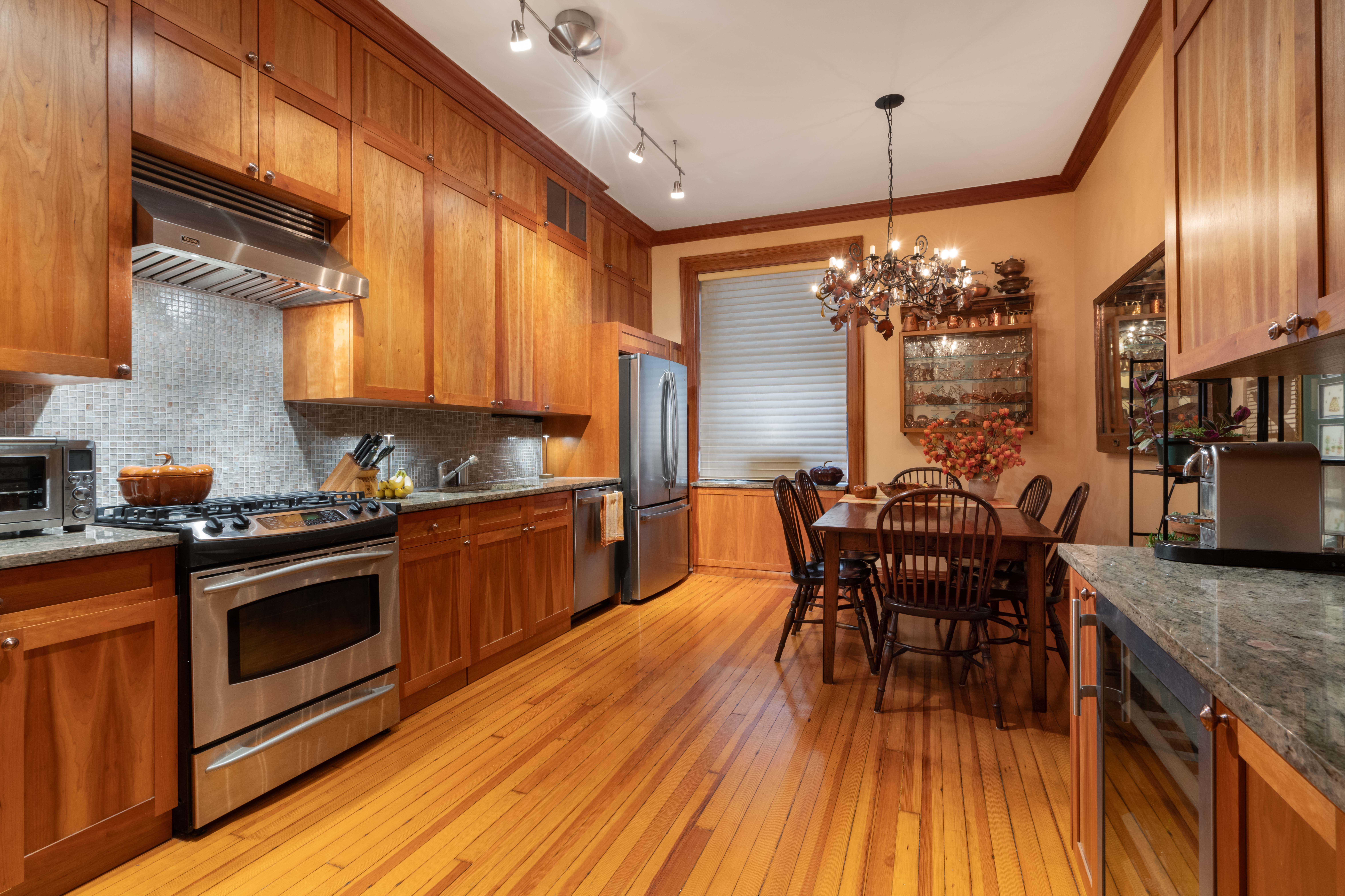 194 Riverside Drive, Unit 4B Manhattan, NY 10025 - Photo 2 of 17 a kitchen with stainless steel appliances granite countertop a kitchen island hardwood floor sink stove dining table and chairs
