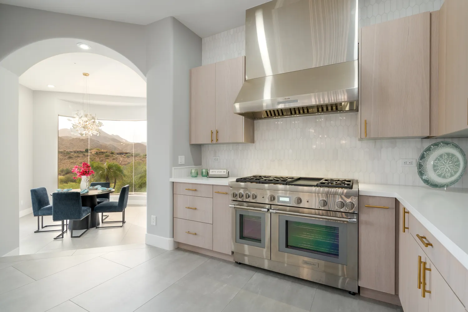 a kitchen with stainless steel appliances a stove a sink and a white cabinets