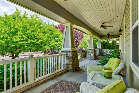 a view of a porch with furniture and a backyard