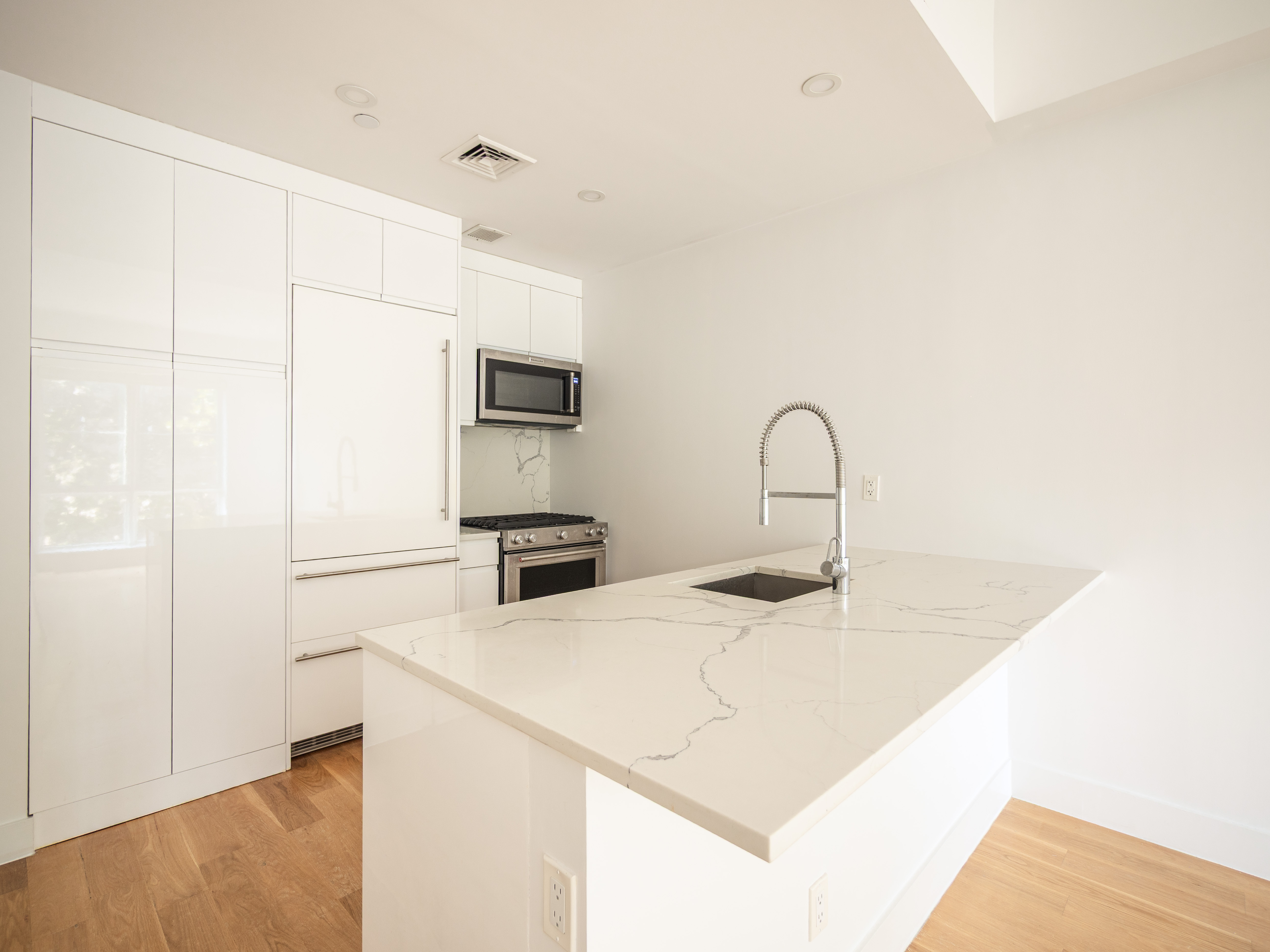 21 Powers Street, Unit 3A Brooklyn, NY 11211 - Photo 7 of 14 a kitchen with a sink a refrigerator and a microwave