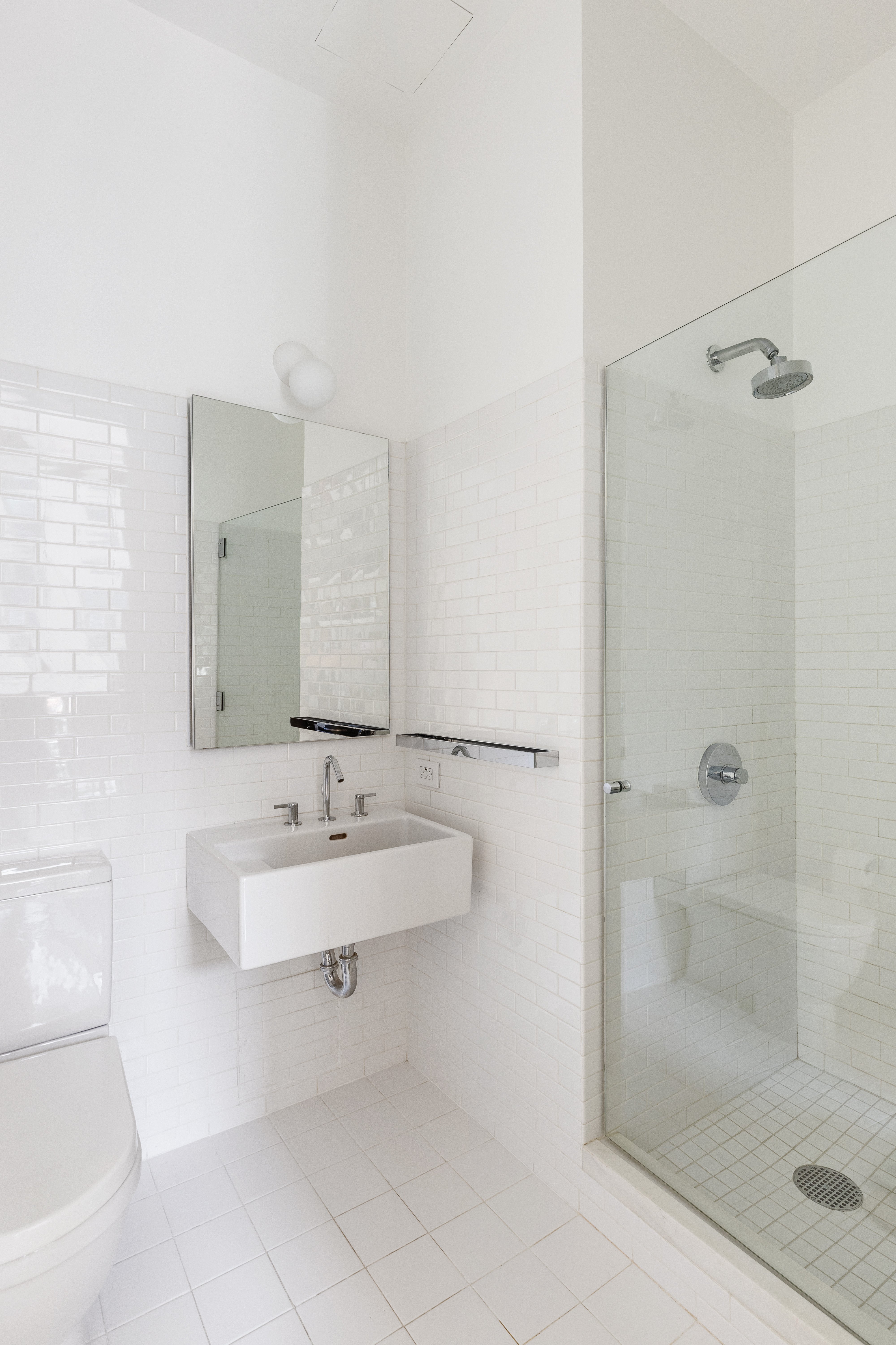 40 Bond Street, Unit 4B Manhattan, NY 10012 - Photo 8 of 9 a bathroom with a bathtub sink vanity and mirror