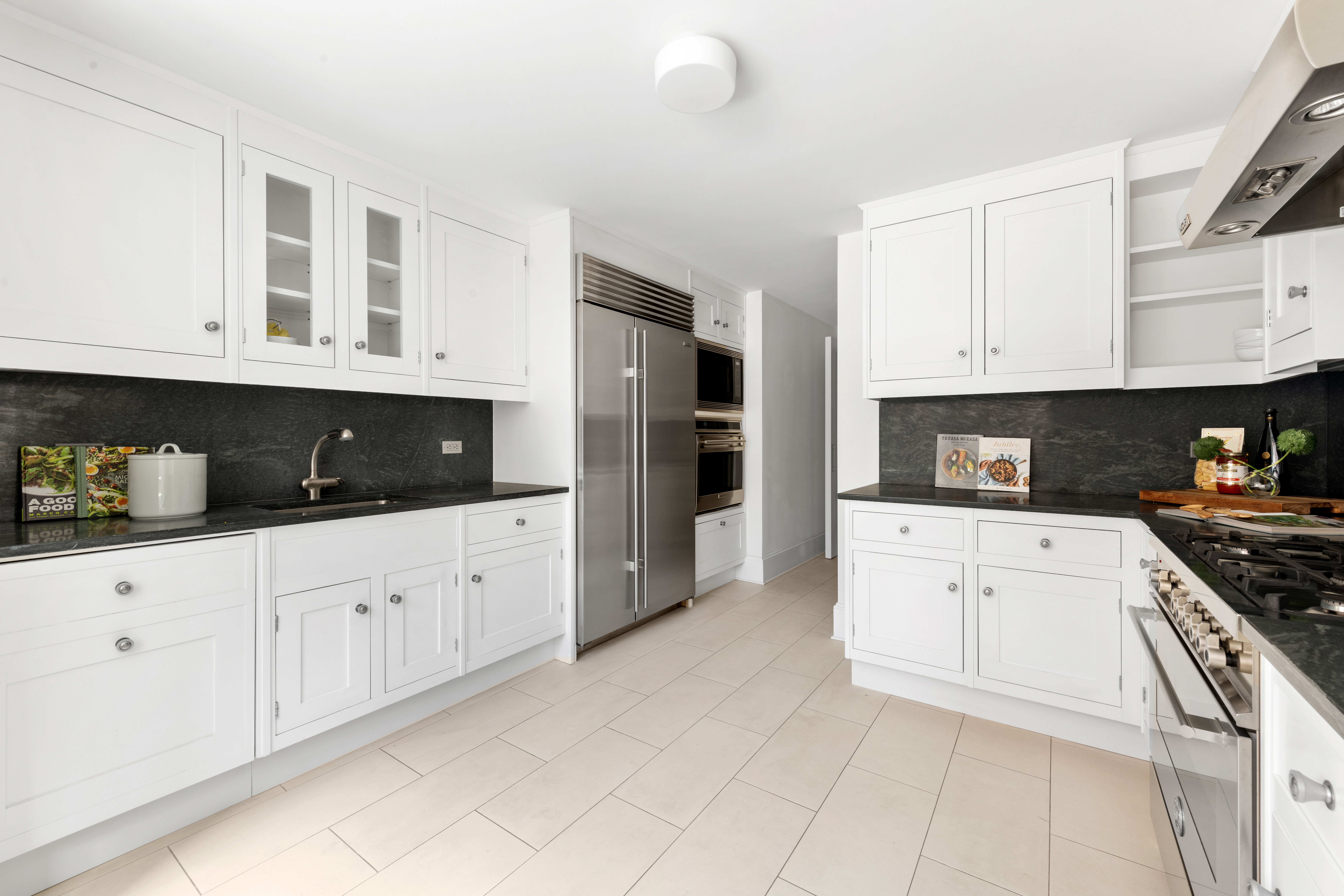 530 Park Avenue, Unit 12A Manhattan, NY 10065 - Photo 9 of 27 a kitchen with stainless steel appliances granite countertop a stove a sink and white cabinets