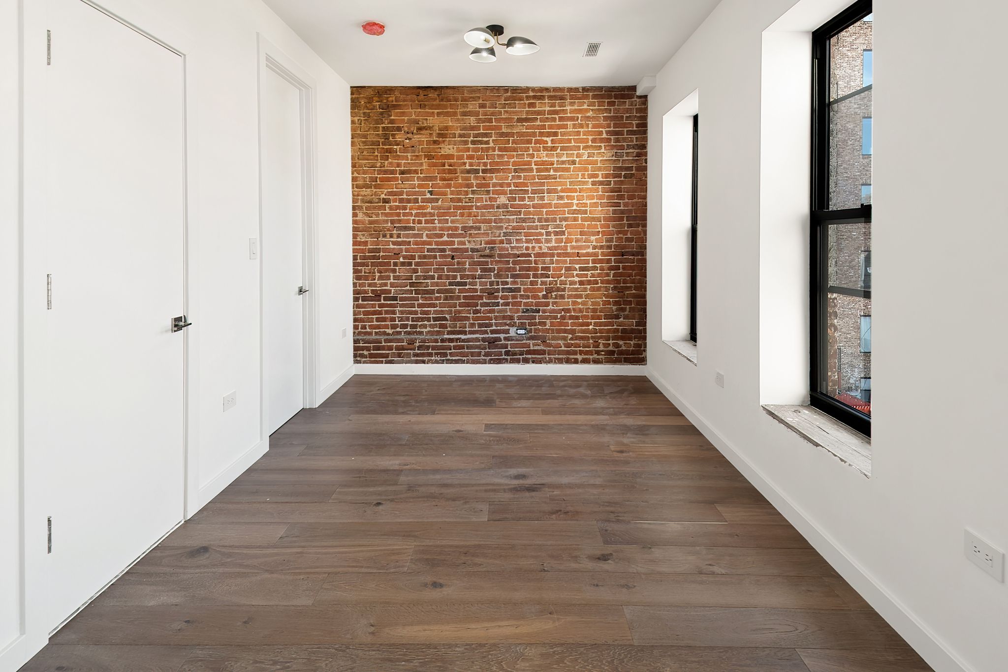 181 Kosciuszko Street Brooklyn, NY 11216 - Photo 15 of 20 a view of an empty room with wooden floor and a window