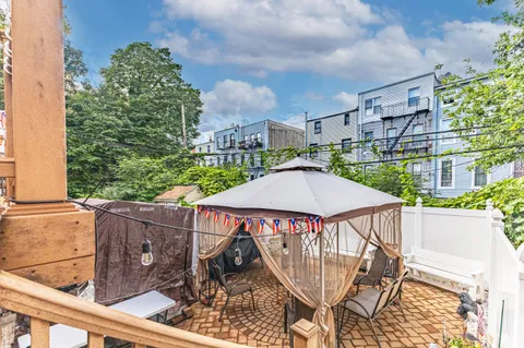 a view of a patio with table and chairs with wooden floor and fence