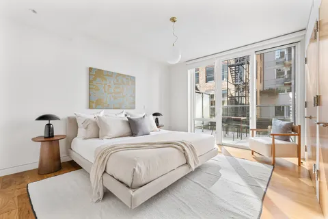 a bedroom with a large bed and a chandelier
