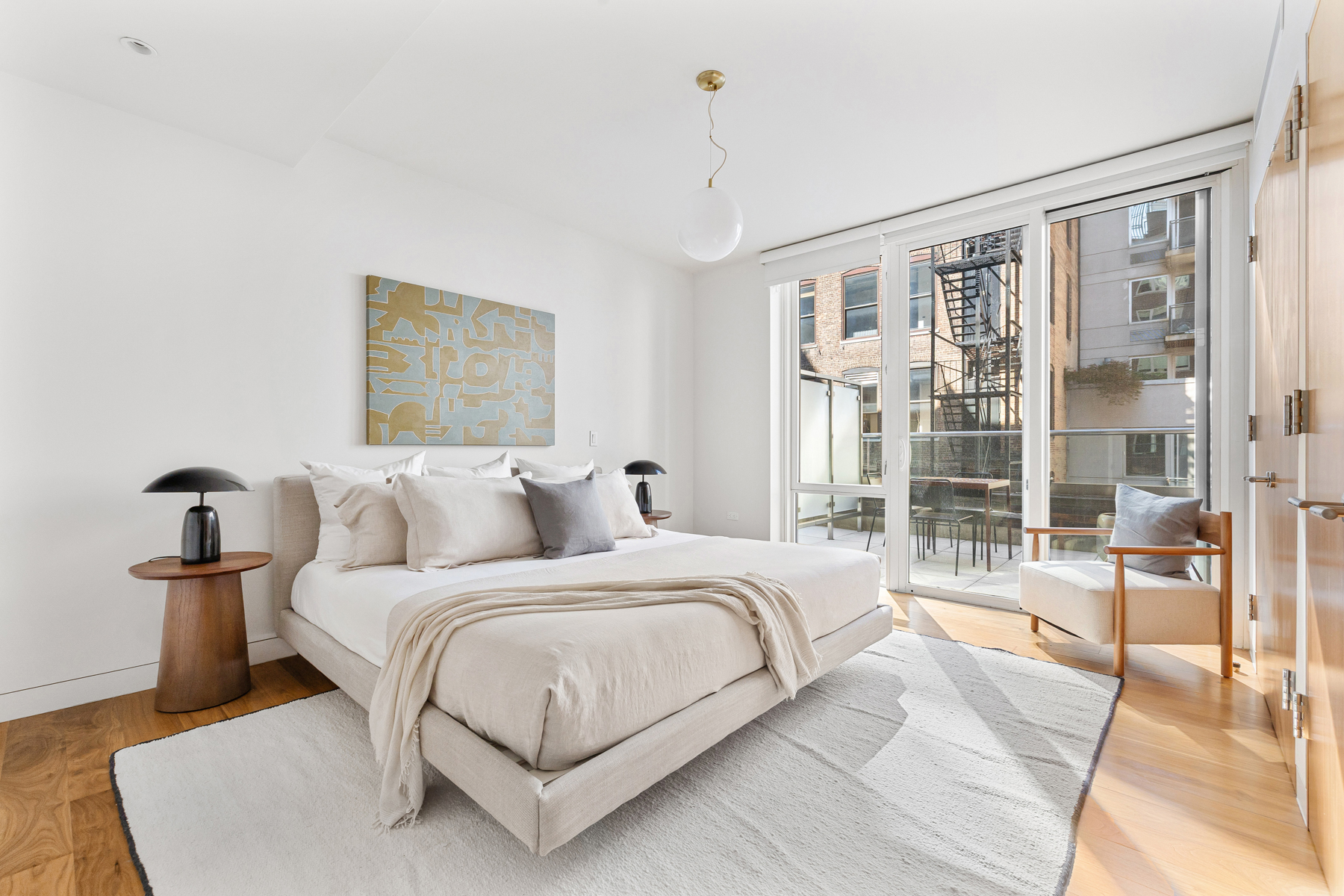151 West 21st Street, Unit 10A Manhattan, NY 10011 - Photo 17 of 26 a bedroom with a large bed and a chandelier