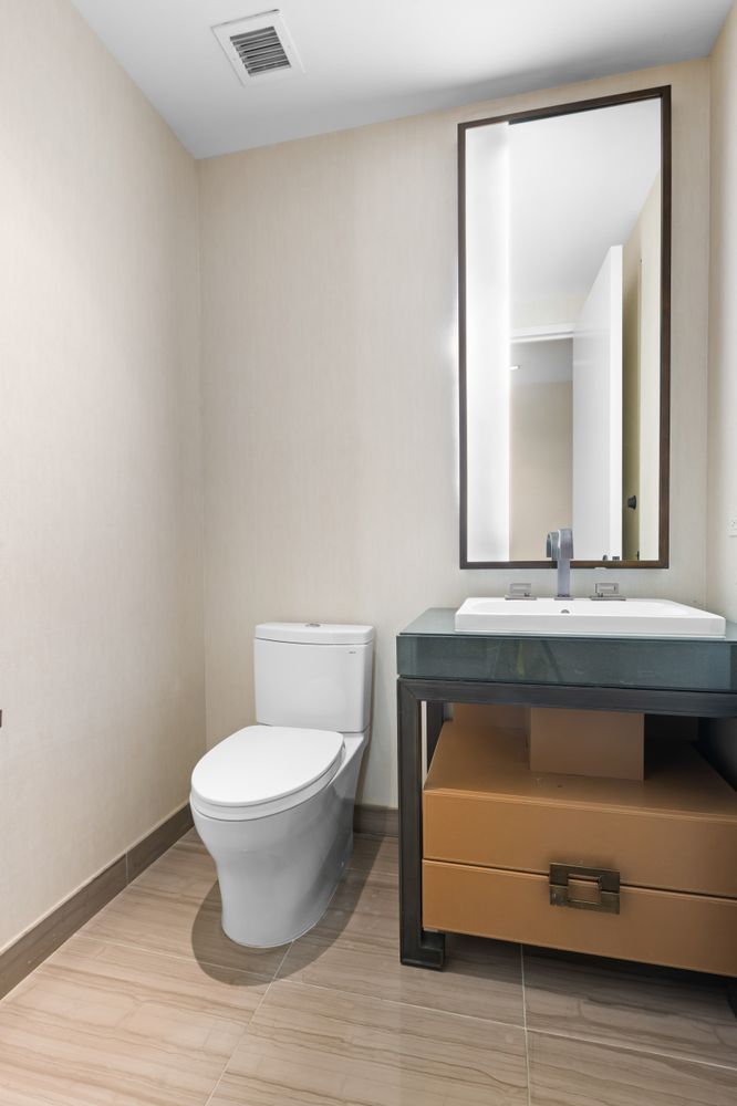 246 Spring Street, Unit 2910 Manhattan, NY 10013 - Photo 13 of 17 a bathroom with a toilet a sink and mirror