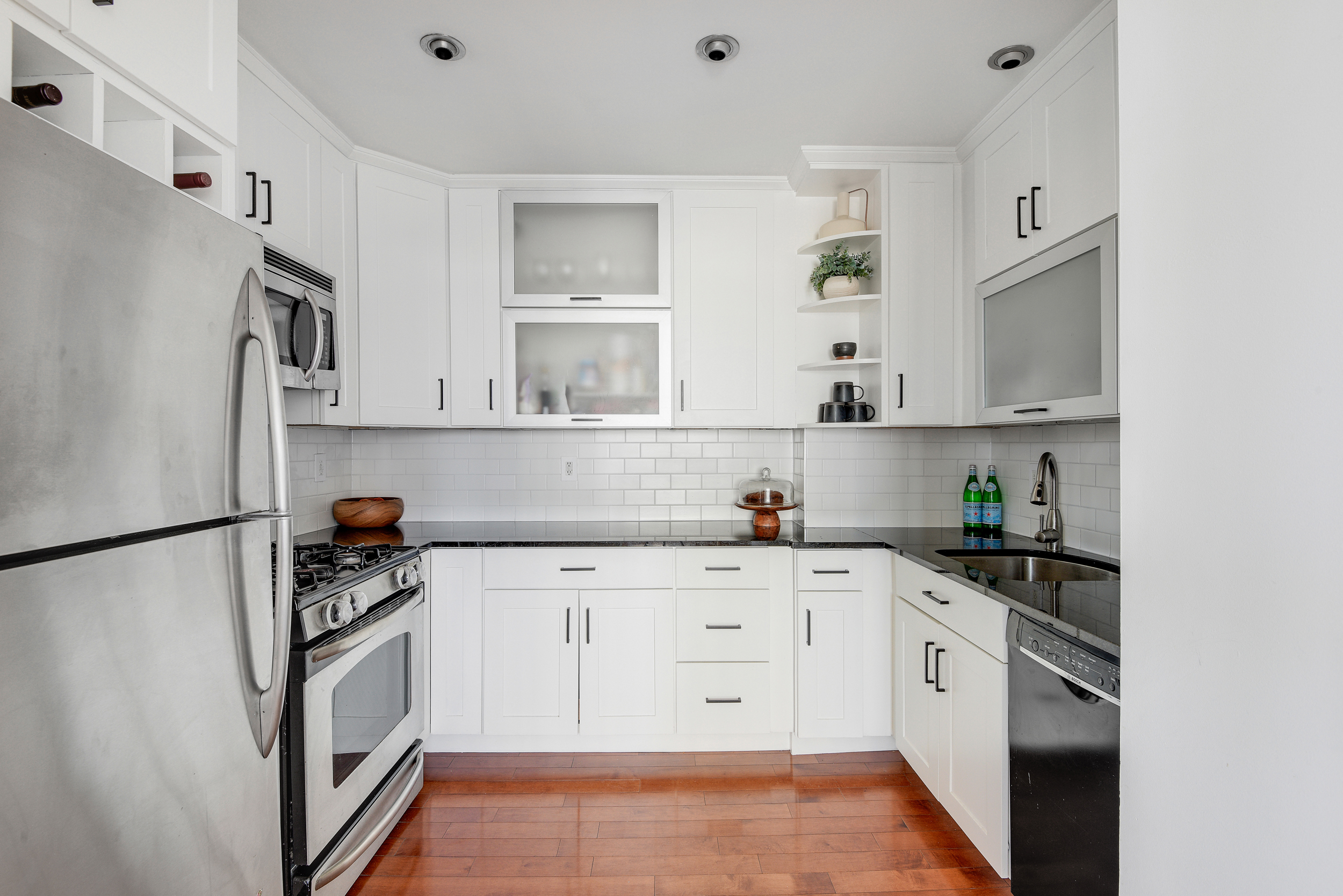 360 East 88th Street, Unit 22C Manhattan, NY 10128 - Photo 10 of 33 a kitchen with stainless steel appliances a refrigerator and white cabinets