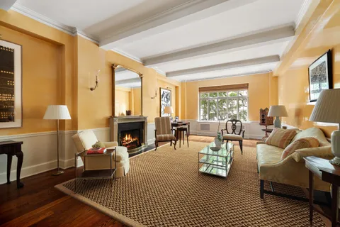 a living room with furniture a fireplace and large windows