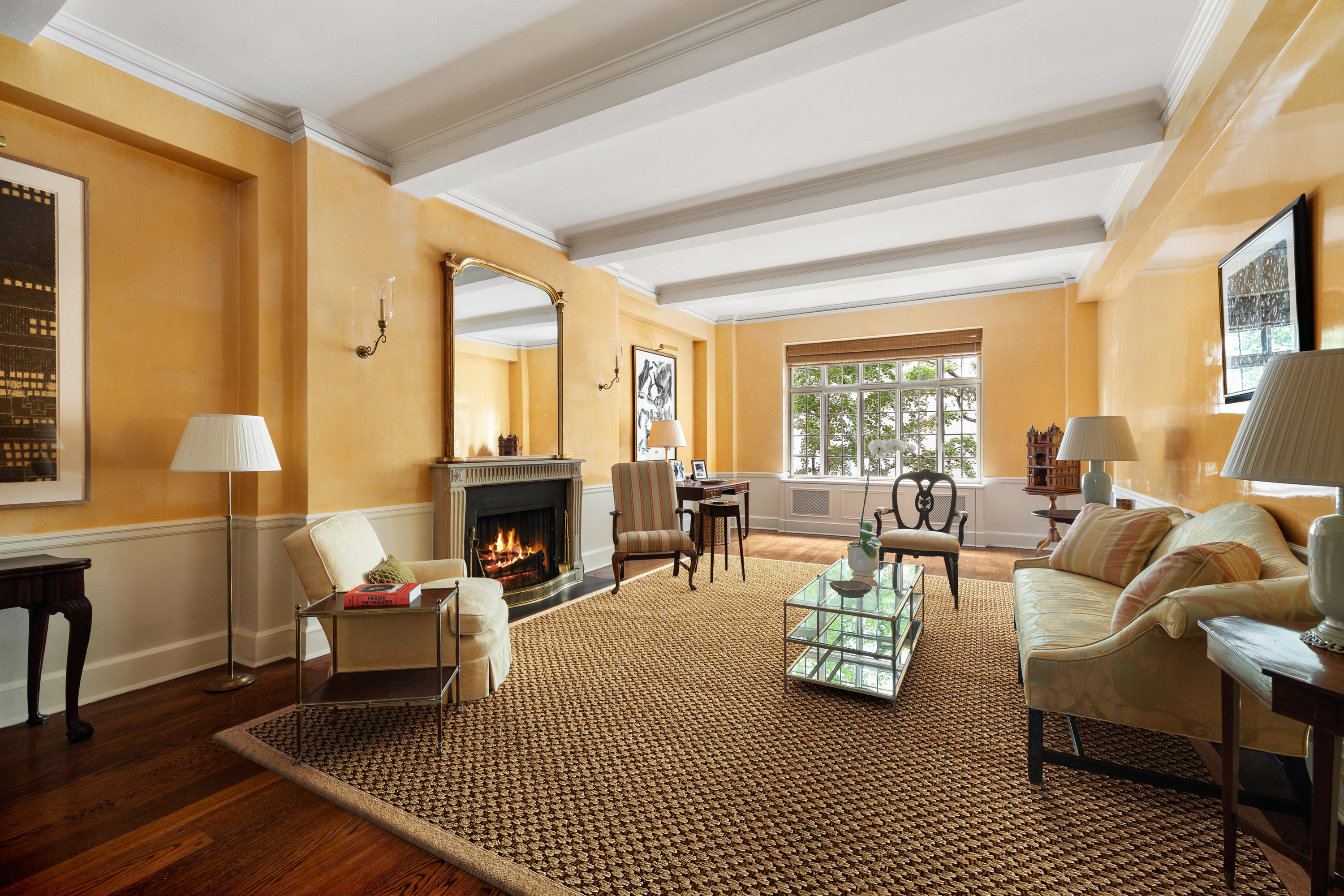 a living room with furniture a fireplace and large windows