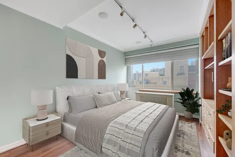 a bedroom with a large bed and a potted plant