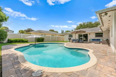 a view of a patio with couches and table and chairs under an umbrella
