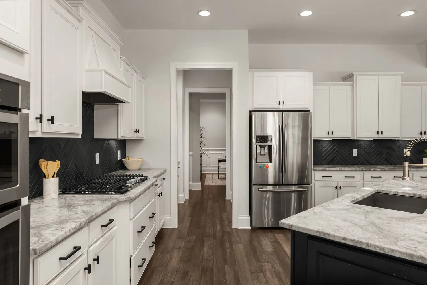 a kitchen with stainless steel appliances kitchen island granite countertop a stove a sink and a refrigerator