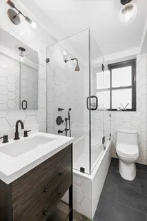 a bathroom with a sink toilet a mirror and shower