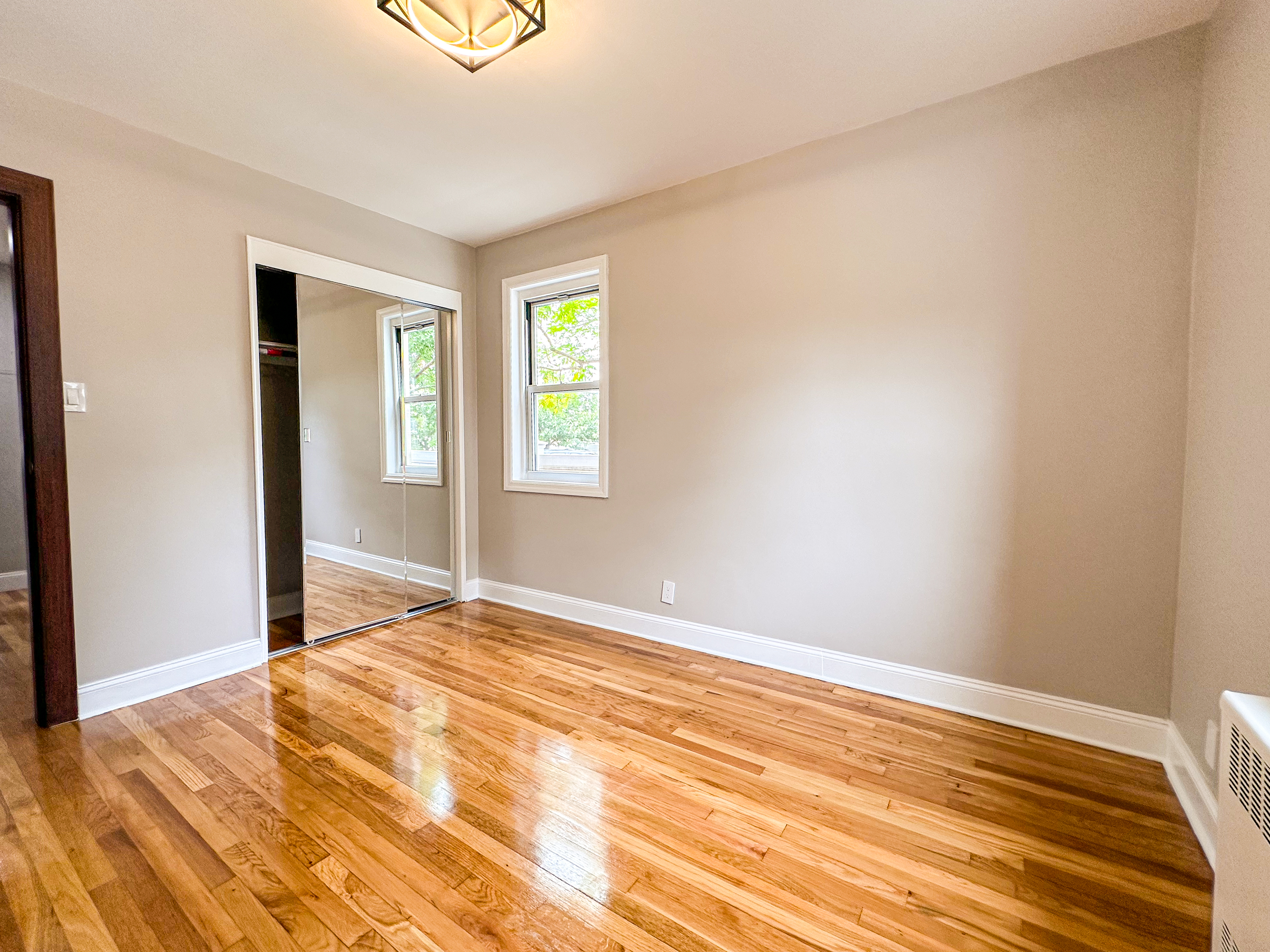 10-01 154th Street, Unit 1 Queens, NY 11357 - Photo 8 of 10 a view of empty room with wooden floor and fan