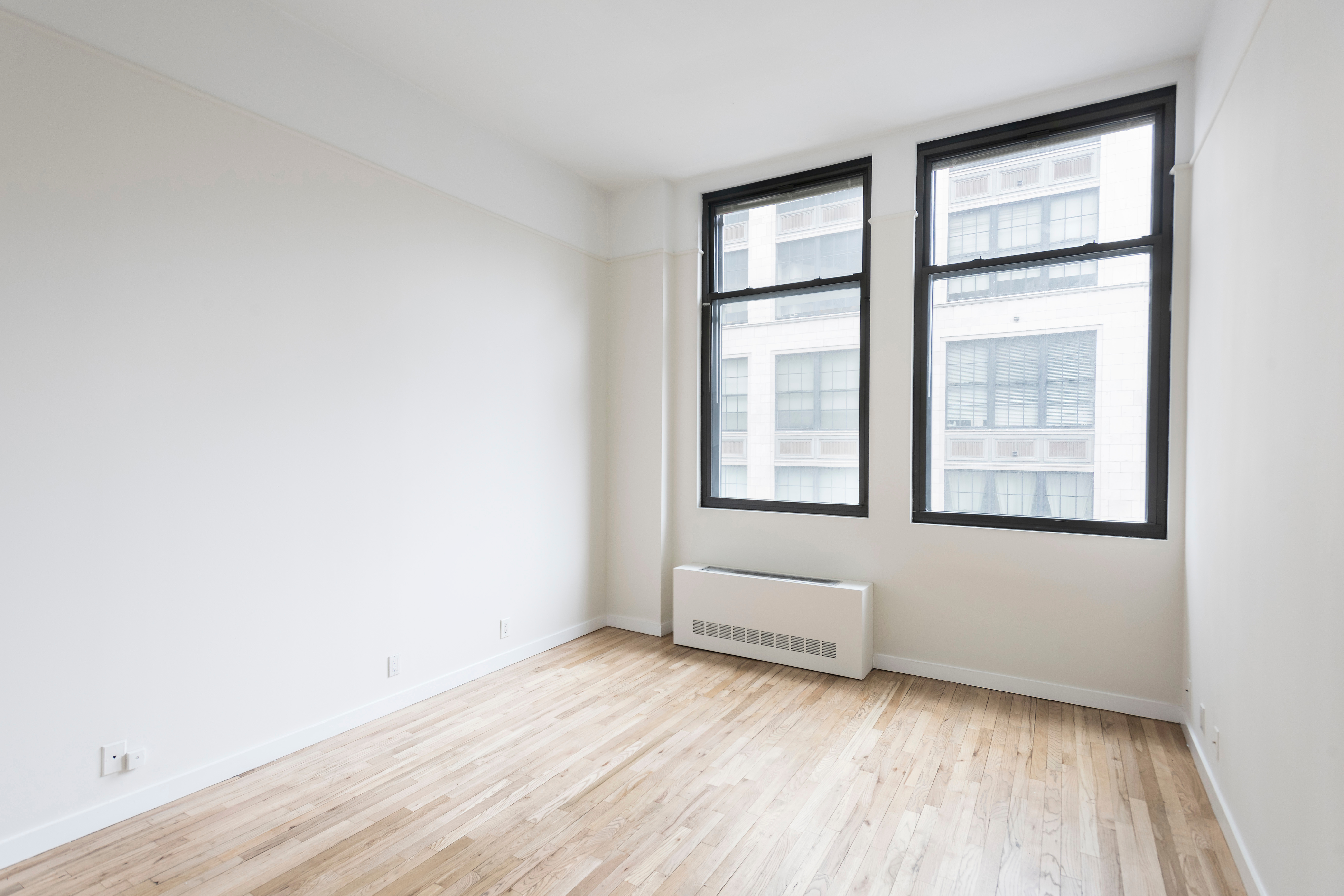 115 4th Avenue, Unit 5C Manhattan, NY 10003 - Photo 6 of 11 an empty room with wooden floor and windows