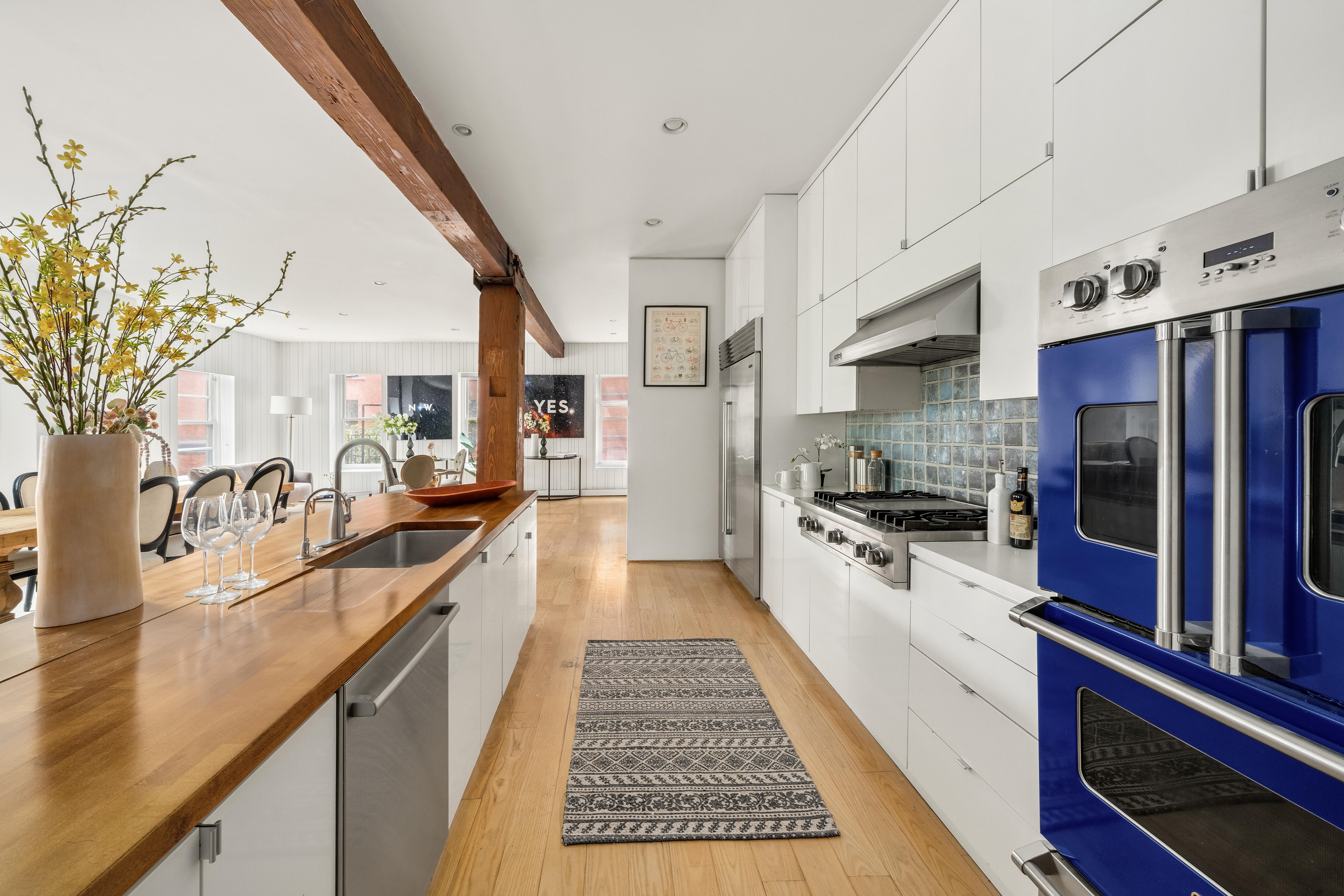 719 Greenwich Street, Unit 3S Manhattan, NY 10014 - Photo 5 of 21 a large white kitchen with stainless steel appliances granite countertop a lot of counter space and wooden floor
