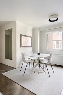a work room with furniture a large window and a table