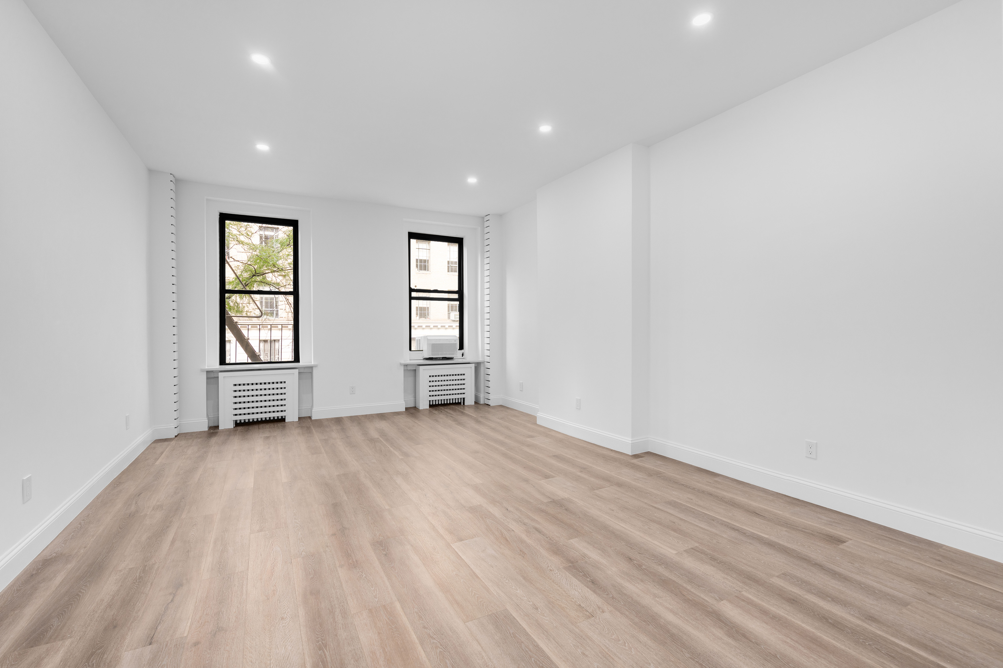 352 West 56th Street, Unit 2A Manhattan, NY 10019 - Photo 4 of 21 an empty room with windows