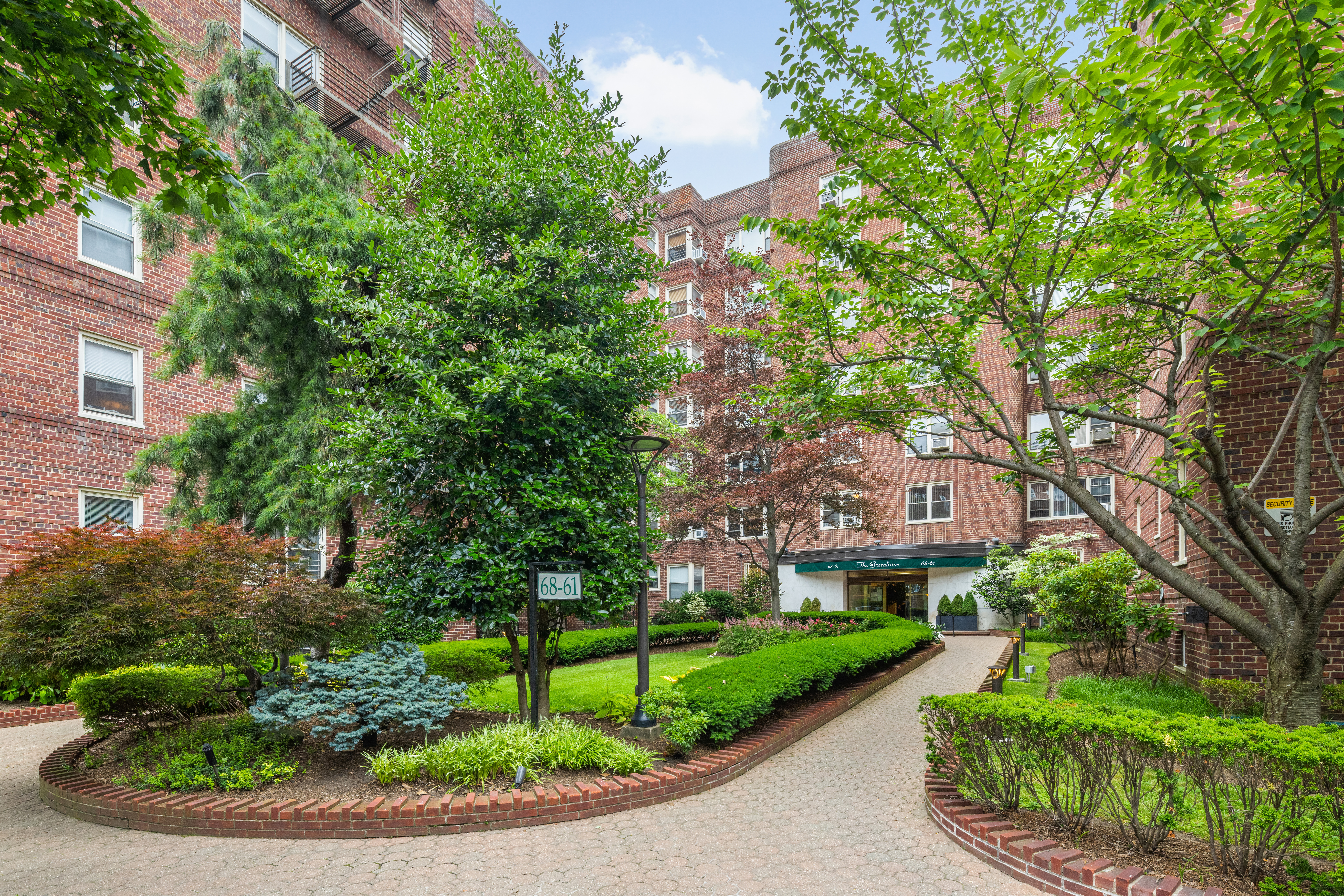 68-61 Yellowstone Boulevard, Unit 618 Queens, NY 11375 - Photo 12 of 13 a view of a big house with a big yard plants and large trees