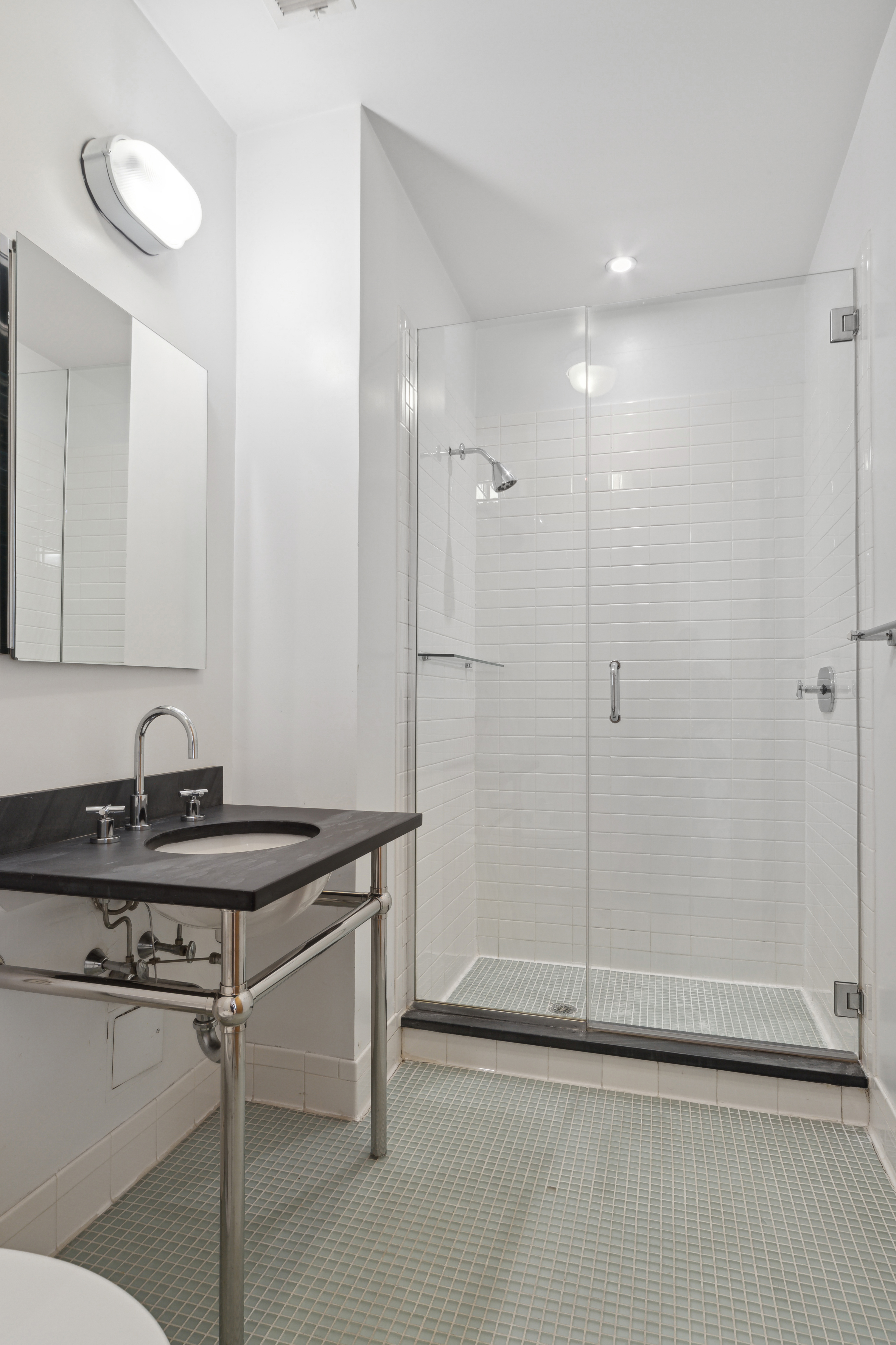 70 Washington Street, Unit 4U Brooklyn, NY 11201 - Photo 6 of 14 a bathroom with a sink a mirror and a shower