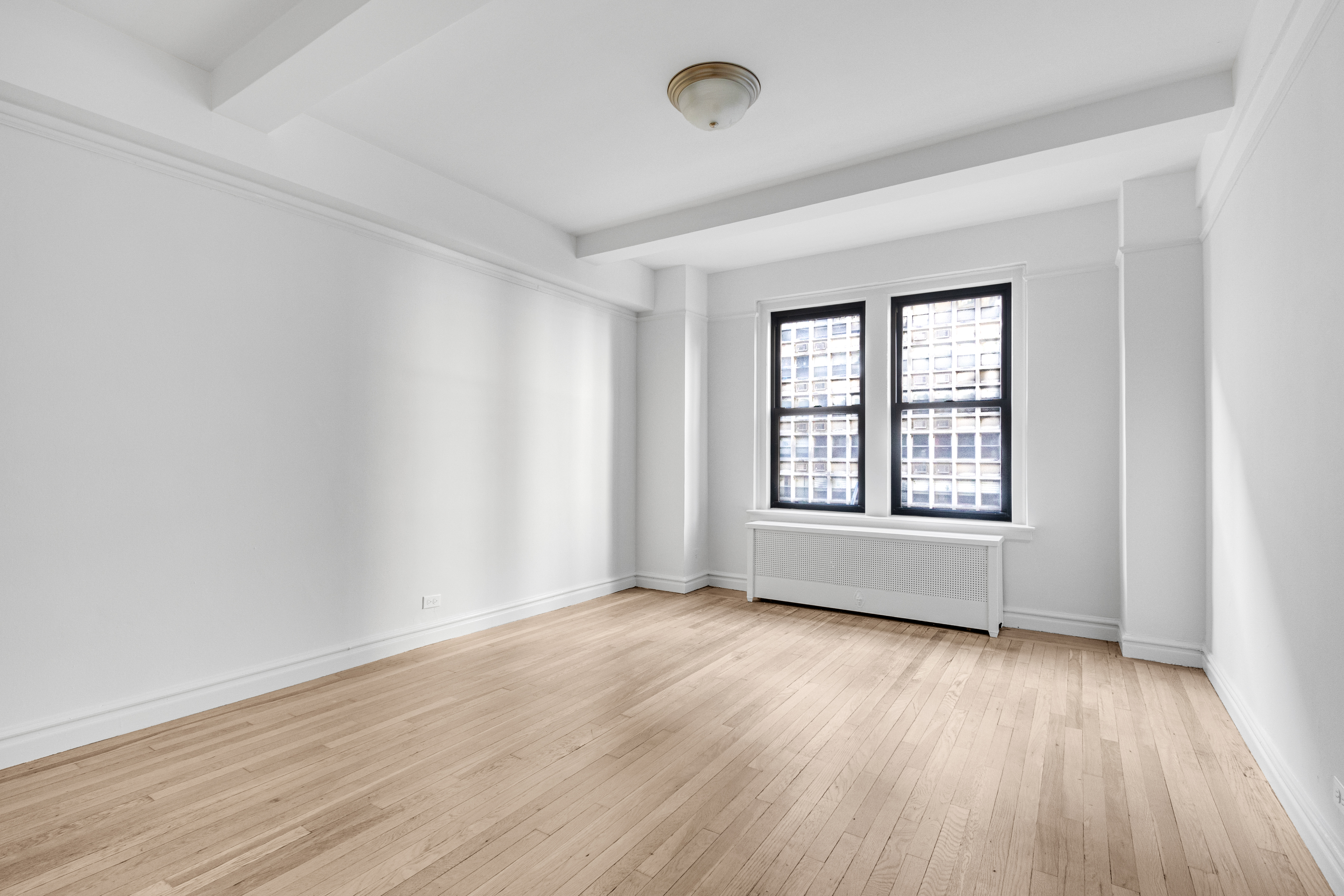 127 West 96th Street, Unit 4D Manhattan, NY 10025 - Photo 7 of 14 an empty room with wooden floor and windows