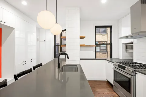 a kitchen with stainless steel appliances a stove a sink a microwave and cabinets