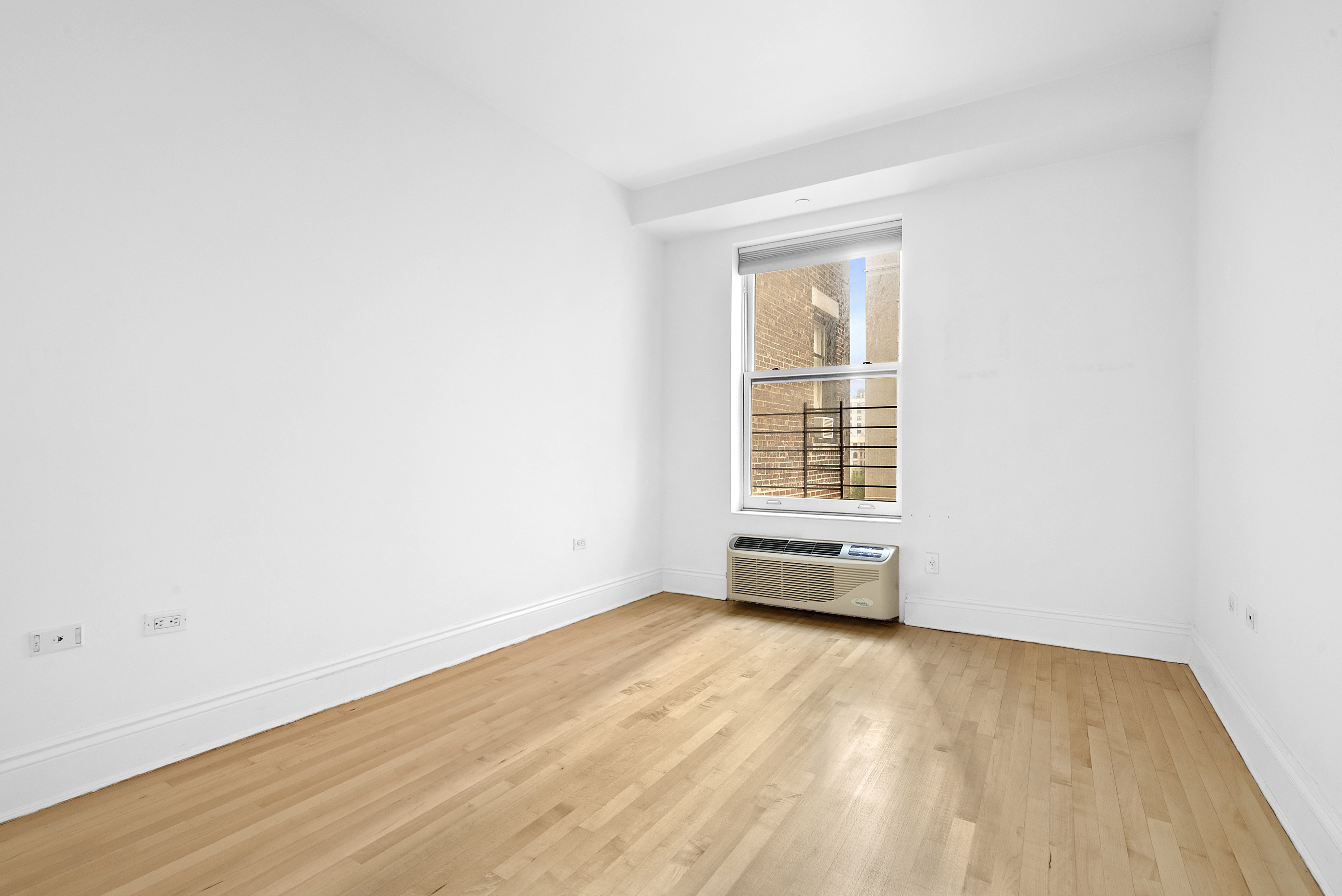 223 West 80th Street, Unit 7 Manhattan, NY 10024 - Photo 3 of 7 an empty room with wooden floor and windows