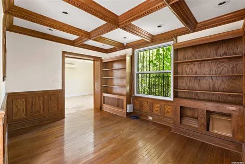 a living room with stainless steel appliances wooden floors and large window