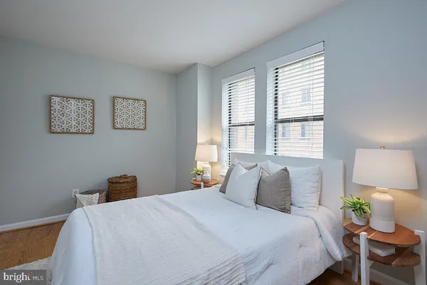 a bedroom with a bed a painting on the wall and a window