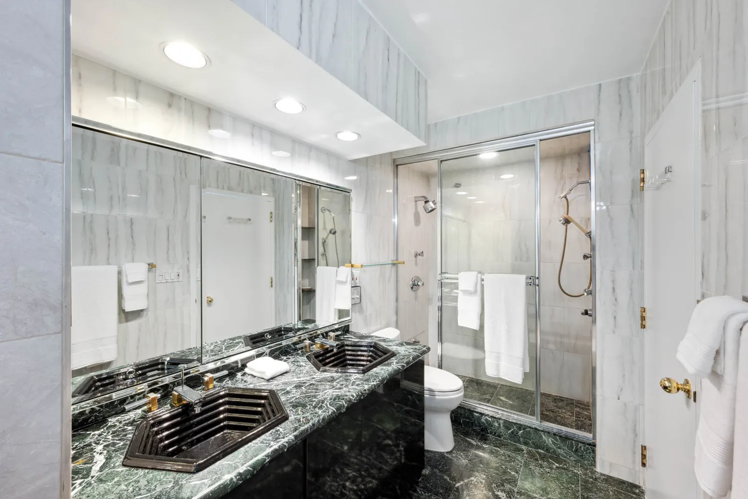 a bathroom with a granite countertop sink a toilet and shower