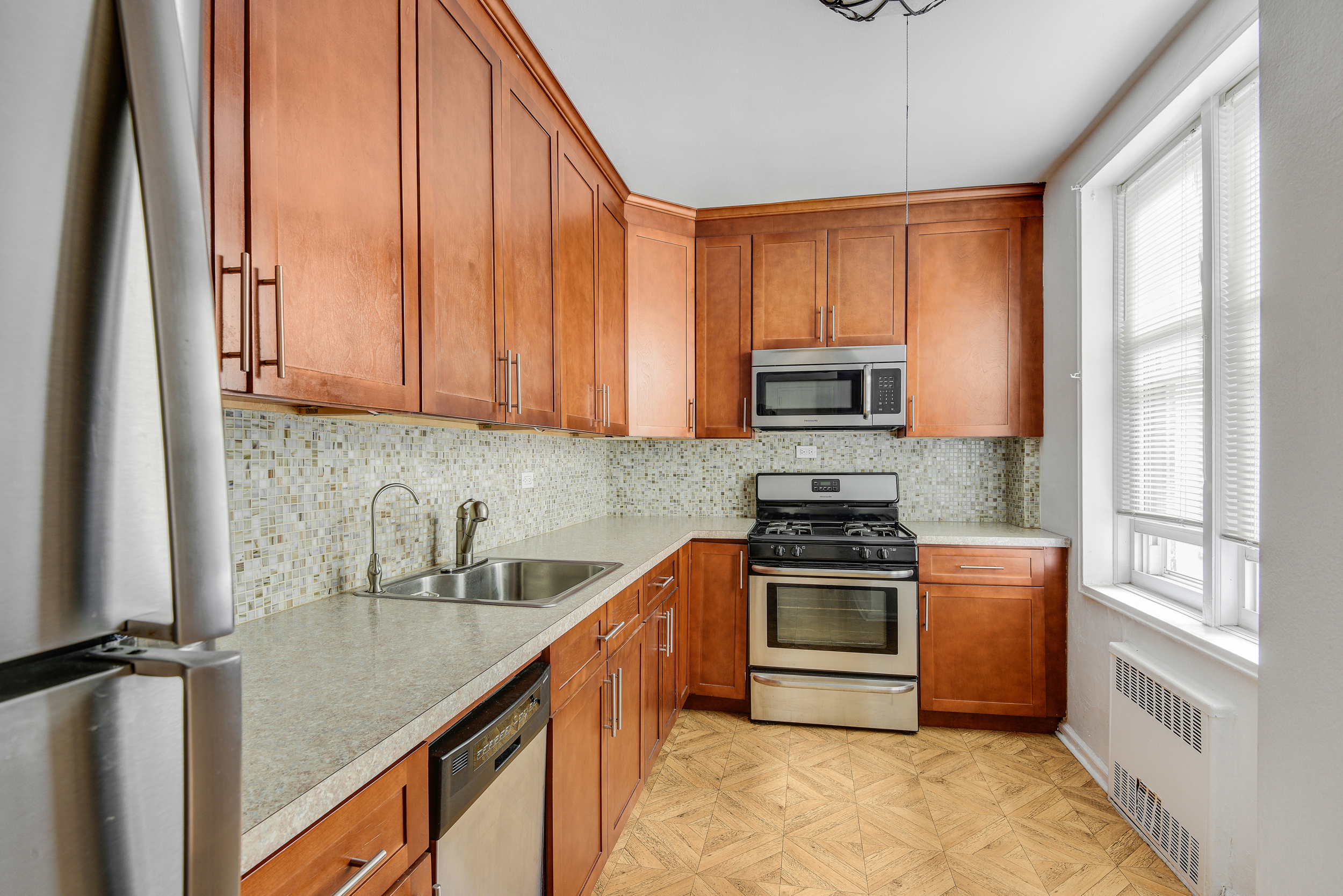 9801 Shore Road, Unit 4P Brooklyn, NY 11209 - Photo 5 of 13 a kitchen with stainless steel appliances granite countertop a stove a sink and a microwave