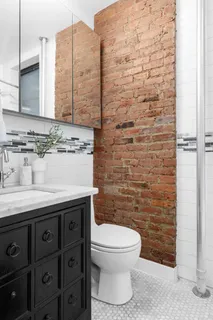 a bathroom with a granite countertop toilet sink and mirror
