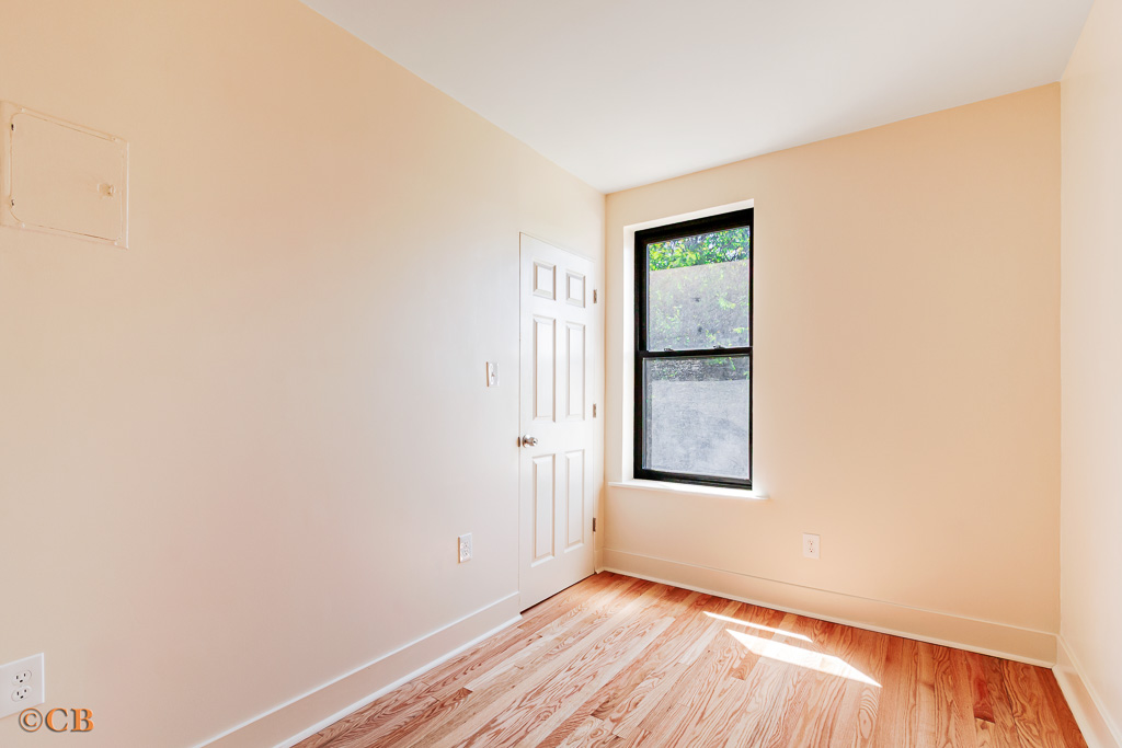 154 Hancock Street, Unit 4F Brooklyn, NY 11216 - Photo 4 of 4 a view of an empty room with wooden floor and a window