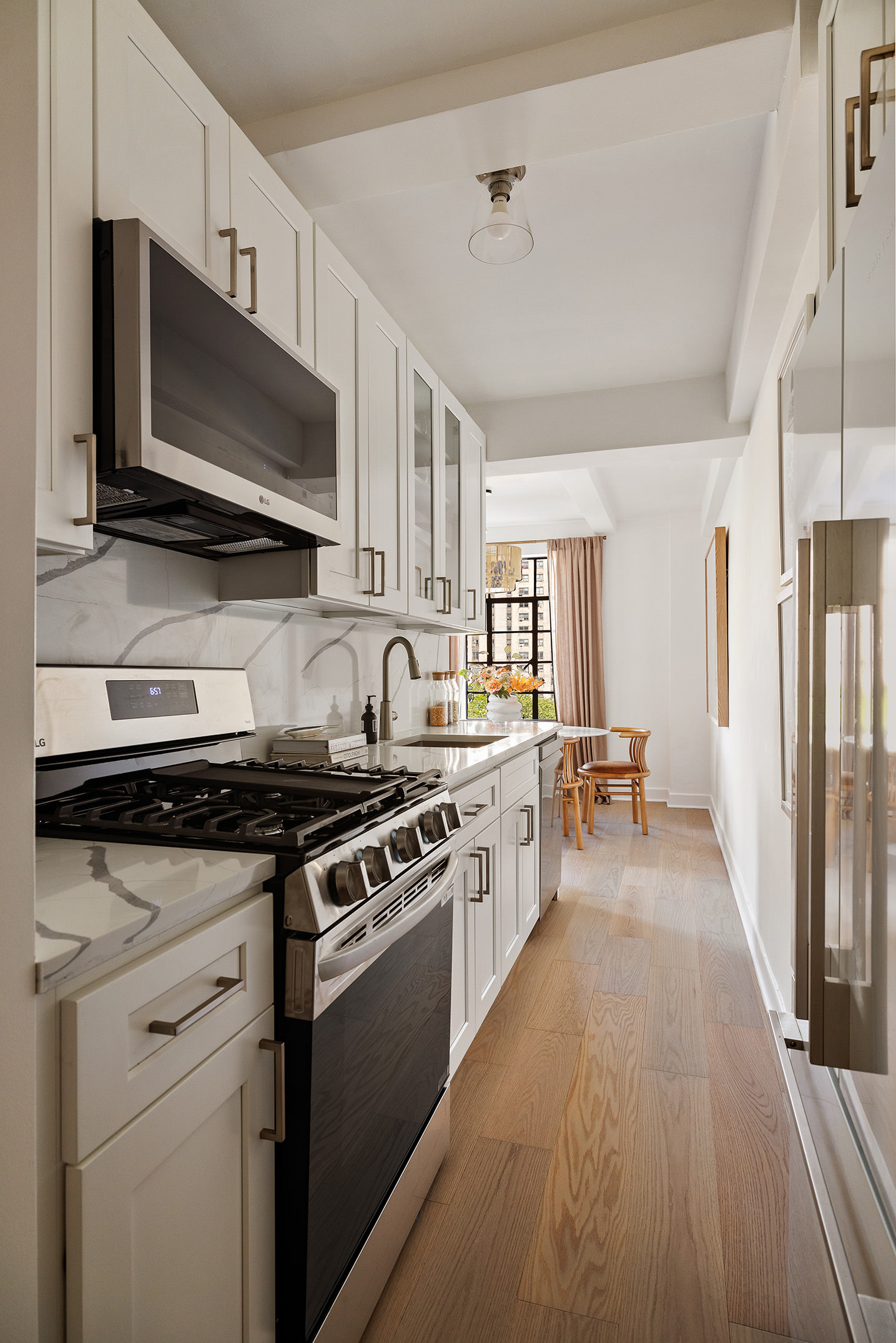 320 Central Park West, Unit 7L Manhattan, NY 10025 - Photo 8 of 16 a kitchen with stainless steel appliances a sink dishwasher stove and oven with wooden floor