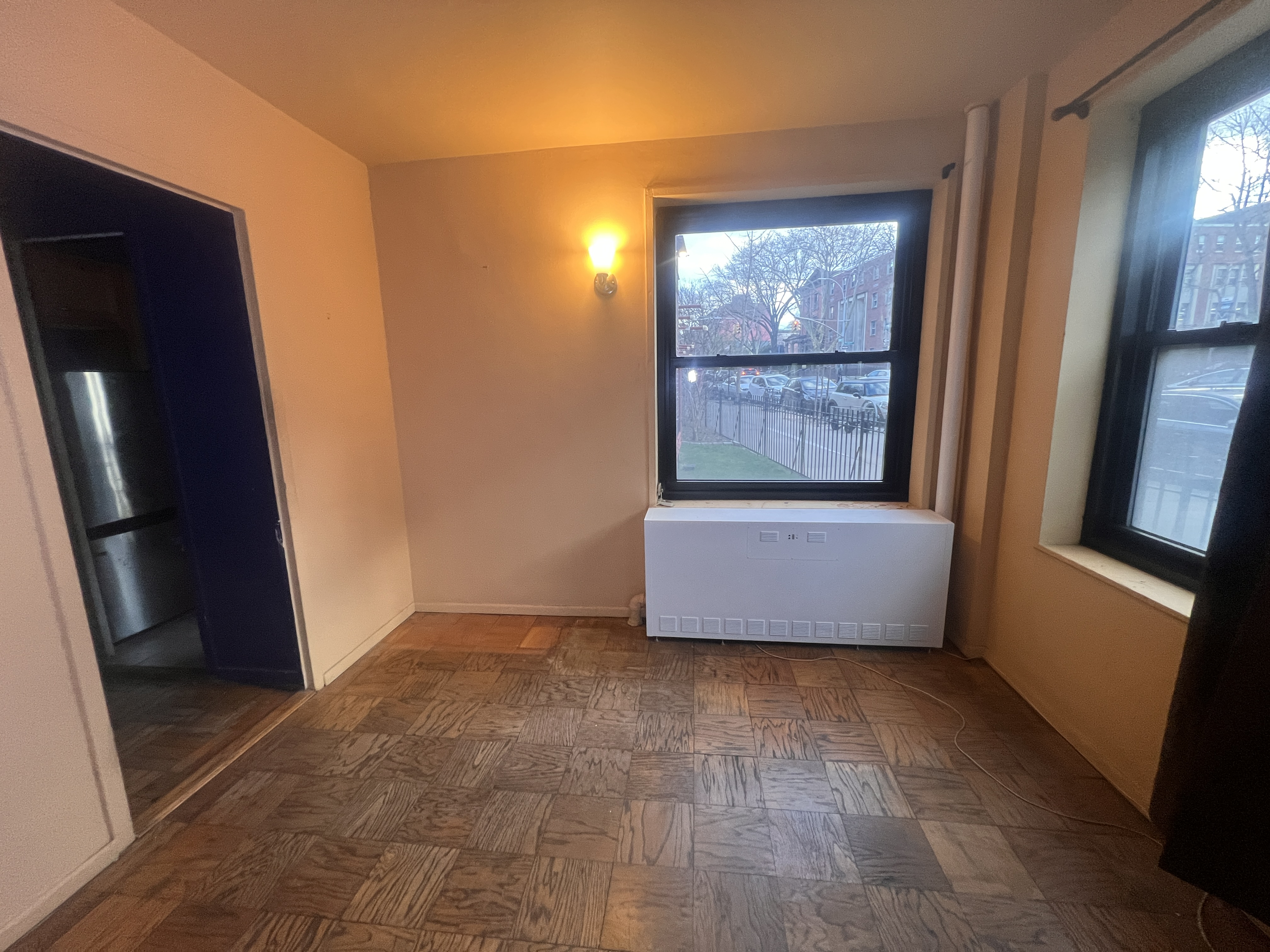 201 Clinton Avenue, Unit 1G Brooklyn, NY 11205 - Photo 6 of 8 a view of an empty room with wooden floor and a window