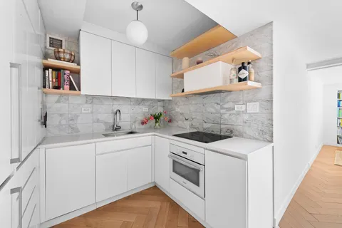 a kitchen with white cabinets and white appliances